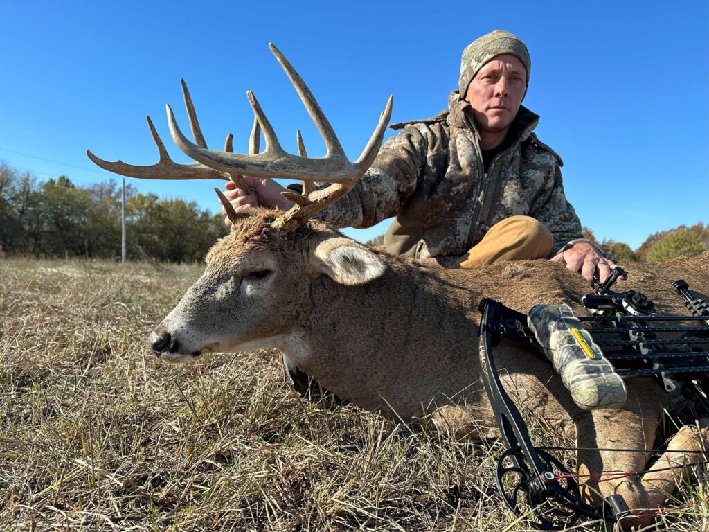 Man posing with deer trophy.